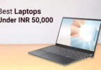 "A premium modern laptop on a wooden office desk displaying a colorful Windows desktop, notebook, coffee cup, wireless mouse, minimal workspace, realistic lighting, ultra-detailed, 8K professional technology photography."