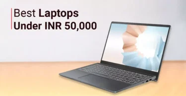 "A premium modern laptop on a wooden office desk displaying a colorful Windows desktop, notebook, coffee cup, wireless mouse, minimal workspace, realistic lighting, ultra-detailed, 8K professional technology photography."